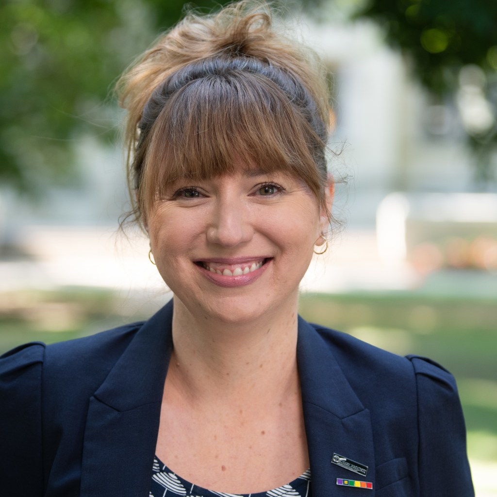 Picture of author Jordan Biro Walters wearing a blue blazer and smiling.